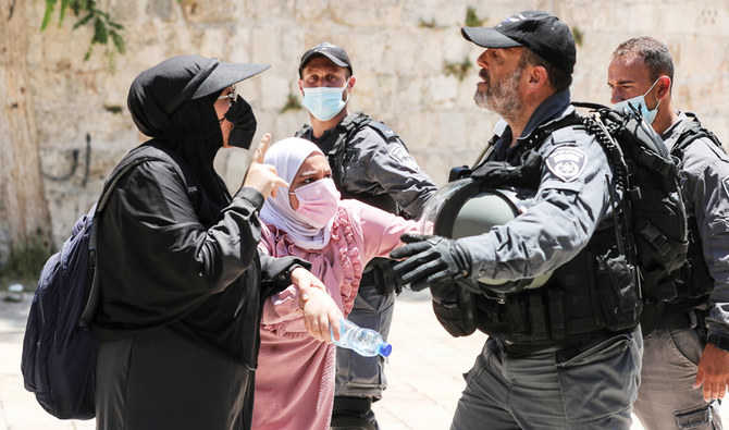 Palestinian women argue with an Israeli security force member after brief clashes erupted between Israeli police and Palestinians at al-Aqsa Mosque in Jerusalem's Old City, July 18, 2021. (Reuters)