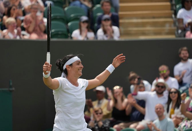 Tunisia's Ons Jabeur celebrates after defeating Poland's Iga Swiatek during the women's singles fourth round match on day seven of the Wimbledon Tennis Championships. (AP)