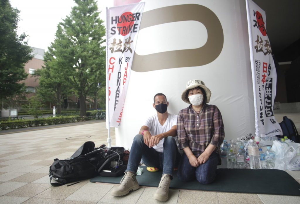 Vincent Fichot receives support from a Japanese friend during his hunger strike 5th day near Tokyo Olympic Stadium to see his “abducted“ children. (ANJ/Pierre  Boutier) 