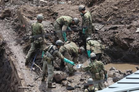 Members of Japan's Self-Defence Forces search for missing people at the scene of a landslide following days of heavy rain in Atami, Shizuoka Prefecture on July 10, 2021. (AFP)