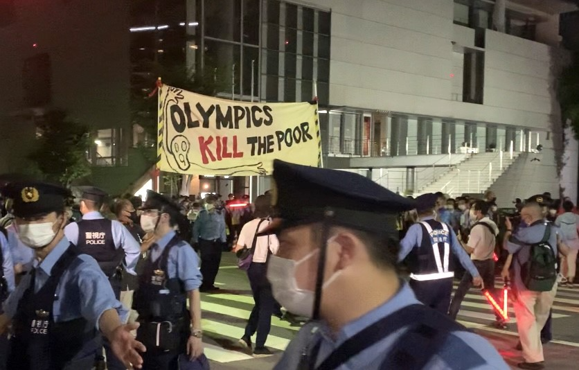 Anti-Olympic protestors hold placards during the fireworks displayed at the closing ceremony. The placards say: “I don't like medals that lack fairness. Not happy to beat a person under bad conditions.” (ANJ photo)