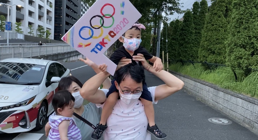 The scene of Japanese kids accompanied by their parents waiting at the entrance of the Olympic Village in Tokyo has become part of daily life for people in the neighborhood. (ANJ photos) 