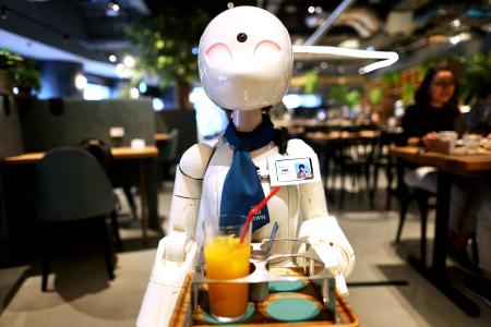 In this picture taken on August 17, 2021, a humanoid robot delivers drinks to customers at the Dawn Cafe in Tokyo. (AFP)