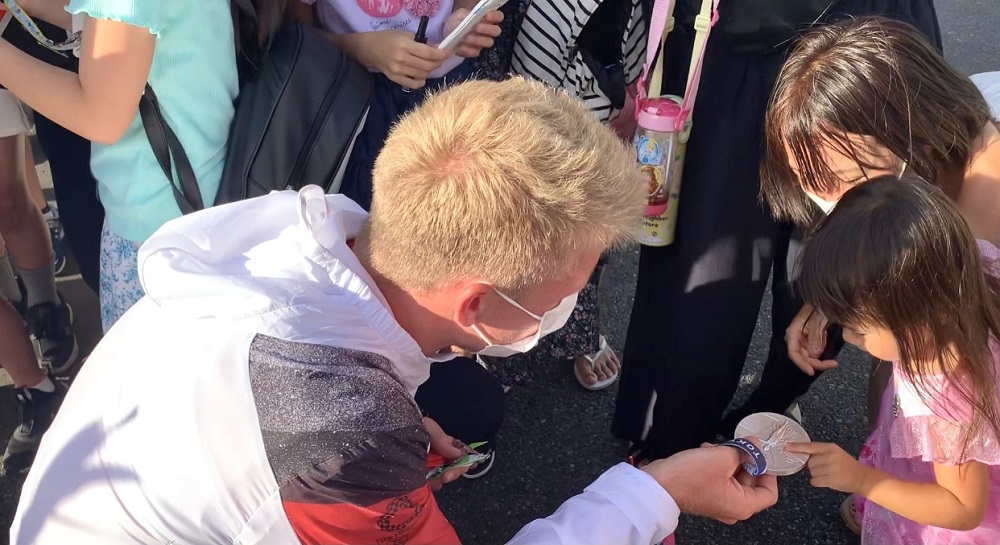 The scene of Japanese kids accompanied by their parents waiting at the entrance of the Olympic Village in Tokyo has become part of daily life for people in the neighborhood. (ANJ photos) 