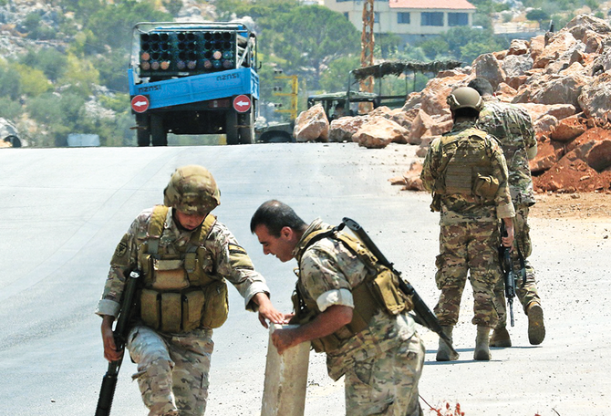 Lebanese soldiers stand near a truck carrying a launcher and multiple rockets after confiscating it, in the southern village of Shouayya. Hezbollah fired more than 10 rockets into Israel, prompting retaliatory shelling. (AFP)