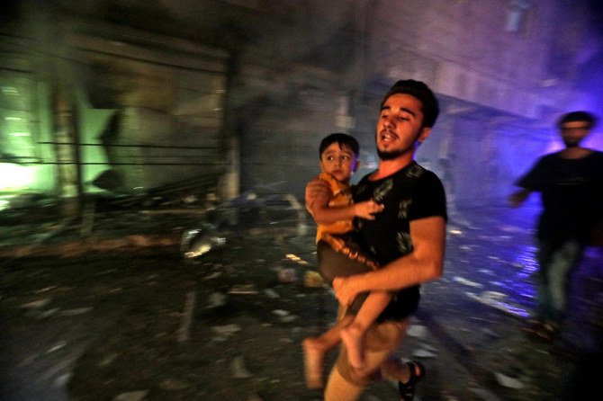 A man flees while evacuating a child in the aftermath of government forces’ bombardment on the rebel-held city of Al-Bab northwest of Aleppo in northern Syria, early on August 6, 2021. (File/AFP)