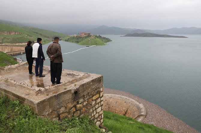 People look at the Dukan dam in Iraq's northern autonomous region of Kurdistan, 65 kms northwest of Suleimaniyah, which was built in 1955 and has reached its highest water levels following heavy rains in the region, on April 2, 2019. (AFP)