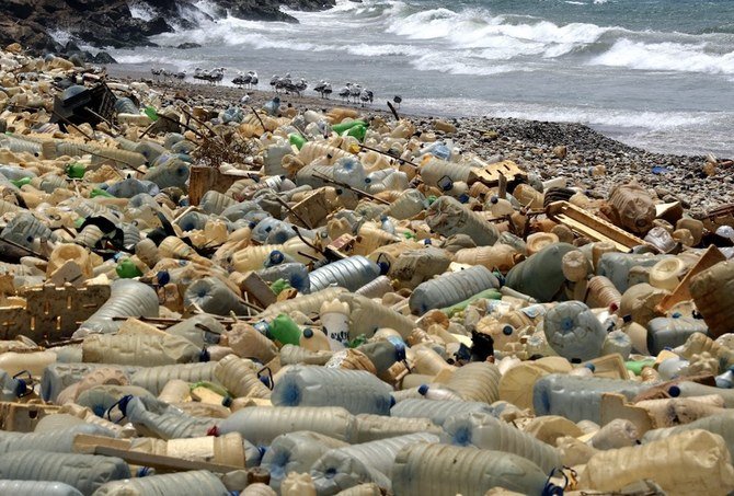 Seagulls search for food near a sewage discharge area next to piles of plastic bottles and gallons washed away by the water on the seaside of Ouzai, south of Beirut. (AFP/File Photo)