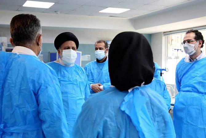 Iranian president Ebrahim Raisi (2n L) during a visit to Imam Khomeini Hospital and Corona Vaccination Center in the capital Tehran. Iran reported over 500 daily COVID-19 deaths for the first time, as new infections also hit a record high. (File/AFP)