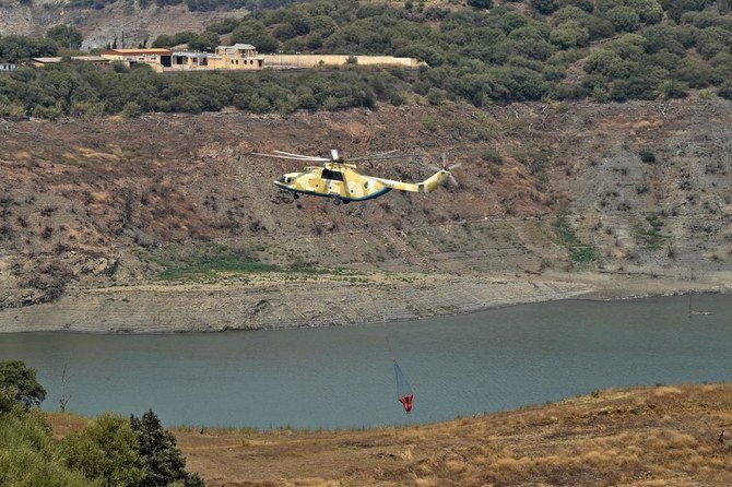 Algeria's Mi-171 helicopter collects water to extinguish a wildfire in the forested hills of the Kabylie region, east of the Algerian capital Algiers, on August 12, 2021. (AFP)