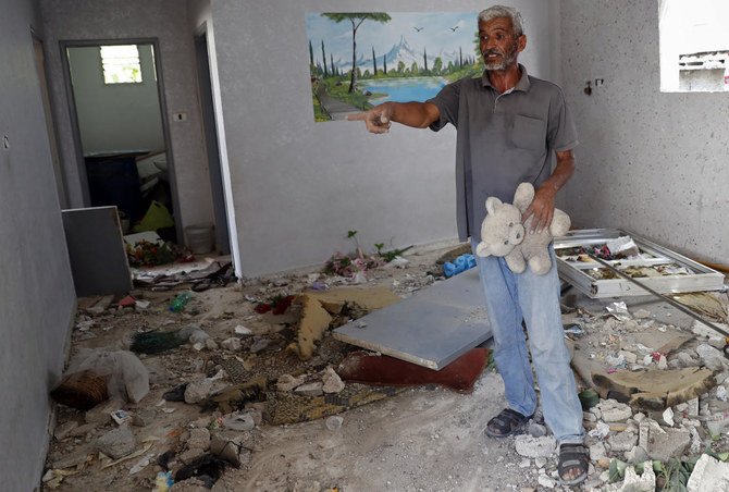 Nasser Abu Fares, who lost three daughters and a grandson when an Israeli artillery bombardment hit his family house during the 11-day war between Israel and Gaza’s Hamas rulers in May, holds his daughter’s teddy bear. (AP)