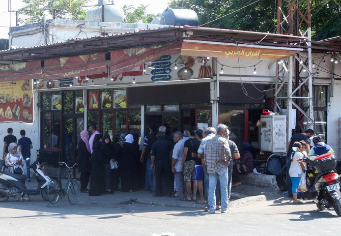 Lebanese people queue outside of a bakery in the southern coastal city of Sidon on August 13, 2021, amidst a deepening economic crisis sparking various shortages of basic staples in the country. (AFP)