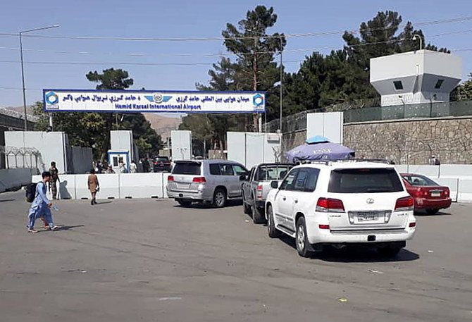 Above, Afghan police check the cars at the entrance gate of Hamid Karzai International Airport in Kabul on Aug. 15, 2021. (Reuters)