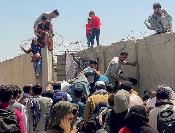 A man pulls a girl to get inside Hamid Karzai International Airport in Kabul. (Reuters)