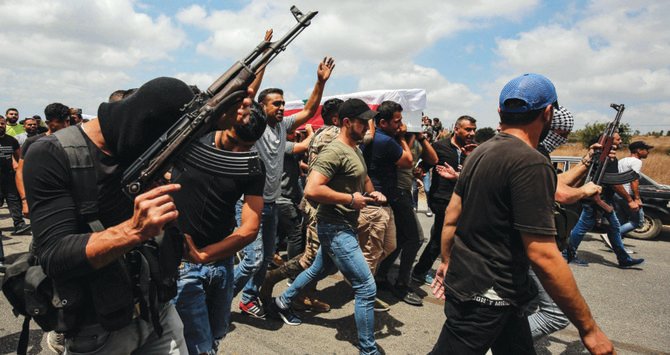 Shots were fired in the air during Wednesday’s funeral of some of the victims of the tank explosion in the village of Al-Daouseh in Lebanon’s Akkar region. (AFP)