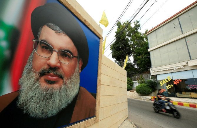 A man rides a motorbike past a picture of Lebanon’s Hezbollah leader Sayyed Hassan Nasrallah in Lebanon. (Reuters)