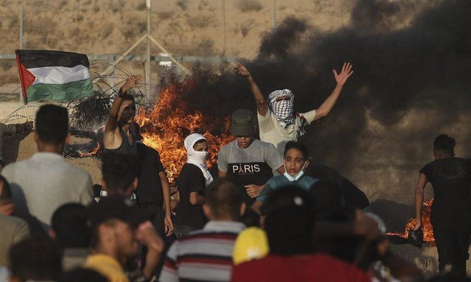 Palestinian demonstrators burn tires during a protest along the border fence in the southern Gaza Strip on Aug. 25, 2021. Violence earlier erupted after Israeli soldiers responded with live fire against the protesters. (AFP)
