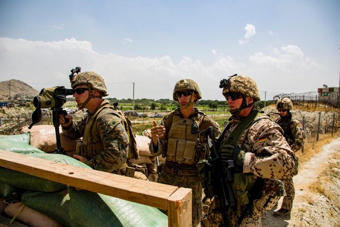 US and German soldiers survey an entry gate at Hamid Karzai International Airport in Kabul on Aug. 28, 2021. (US Marine Corps photo via AP)