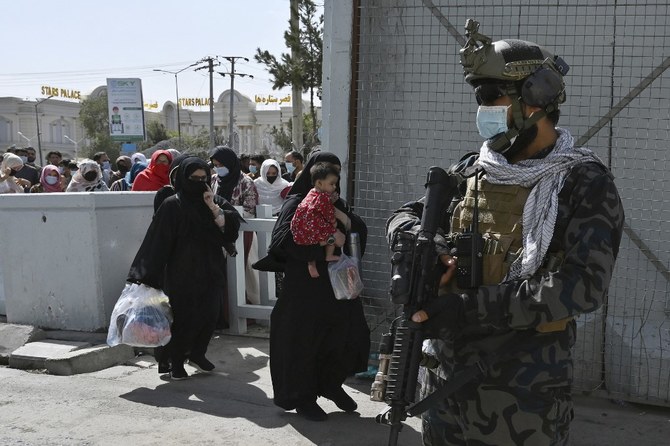 A Taliban Badri fighter, a ‘special forces’ unit, stands guard as Afghans hoping to leave the country walk through the main entrance gate of Kabul airport on Aug. 28, 2021. (AFP)