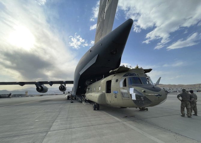 A CH-47 Chinook from the 82nd Combat Aviation Brigade, 82nd Airborne Division is loaded onto a U.S. Air Force C-17 Globemaster III at Hamid Karzai International Airport in Kabul, Afghanistan, Saturday, Aug. 28, 2021. (Department of Defense via AP)