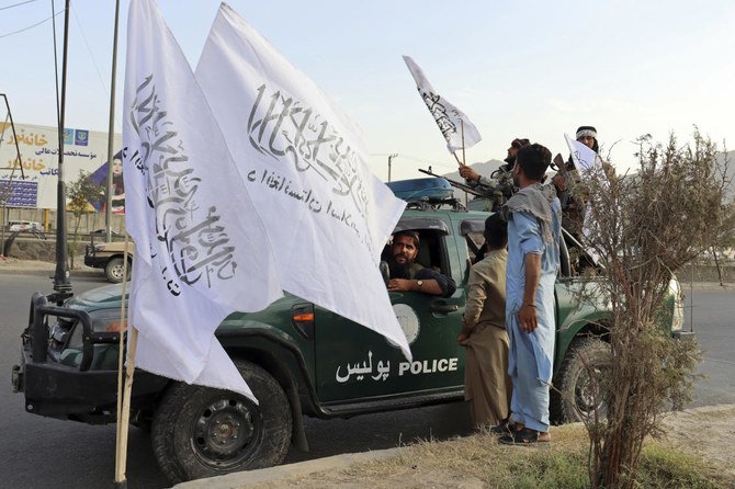 Taliban fighters buy Taliban flags in Kabul, Afghanistan, Monday. (AP)