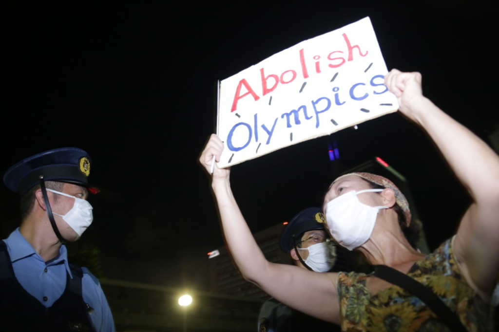 Anti-Olympic protestors hold placards during the fireworks displayed at the closing ceremony. The placards say: “I don't like medals that lack fairness. Not happy to beat a person under bad conditions.” (ANJ photo)