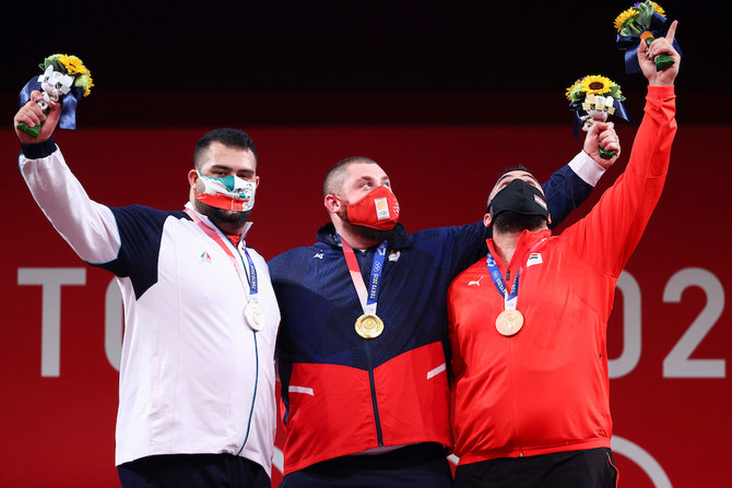 Gold medalist Lasha Talakhadze of Georgia (center), silver medalist Ali Davoudi of Iran (left), and bronze medalist Man Asaad of Syria at the +109kg weightlifting medal ceremony, Tokyo, Japan, Aug. 4, 2021. (Reuters)