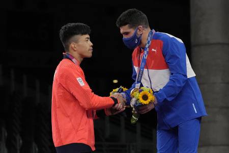 Japan's Kenichiro Fumita (left) congratulates Cuba's Luis Orta Sanchez during the medal ceremony for the men's 60kg Greco-Roman wrestling final match. (AP)