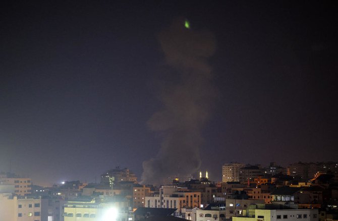 Explosions light-up the night sky above buildings in Gaza City as Israeli forces shell the Palestinian enclave, early on Aug. 22, 2021. (File/AFP)