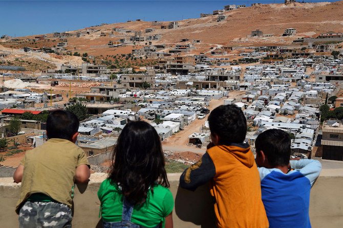 Lebanese children look at a Syrian refugee camp in the eastern border town of Arsal, Lebanon, on June 16, 2019. (AP Photo)