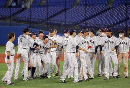 Japan's baseball players and coaches celebrate their victory after the extra tenth inning in the Tokyo 2020 Olympic Games baseball round 2 game between USA and Japan at Yokohama Baseball Stadium in Yokohama, Japan, on August 2, 2021. (AFP)