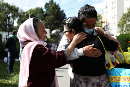 Shakiba Dawod, an Afghan artist who lives in France since 2009, hugs her brother Mahdi and her mother Qadira near Paris on Friday as they reunite for the first time in 12 years, following Shakiba’s family evacuation from Afghanistan. (Reuters)