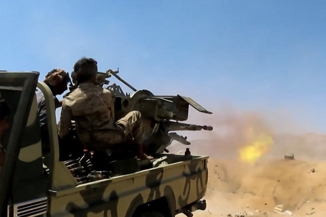 A fighter loyal to Yemen's government fires a turret mounted in the back of a pickup truck at a position in the region of Al-Kassara, northwest of Marib. (File/AFP)