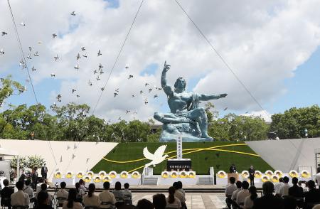 Doves fly during a memorial service for victims of the US atomic bombing at the Nagasaki Peace Park in Nagasaki on August 9, 2021, as the city marks the 76th anniversary of the bombing. (AFP)