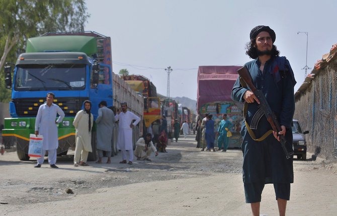A Taliban fighter stands guard on Afghan side while people wait to cross at a border crossing point between Pakistan and Afghanistan, in Torkham, in Khyber district, Pakistan, Saturday, Aug. 21, 2021. (AP)