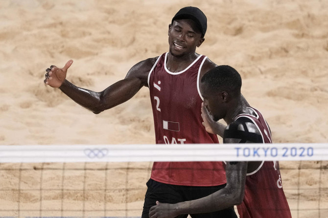 Cherif Younousse (left), of Qatar, and teammate Ahmed Tijan, celebrate winning a men's beach volleyball quarterfinal match against Italy on Aug. 4, 2021. (AP)