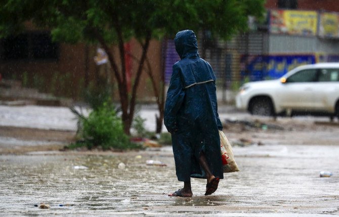 A woman walks along a flooded street in Khartoum after torrential rain fell on the Sudanese capital, almost paralizing traffic, on August 8, 2021. (File/AFP)