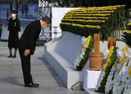 Japan's Prime Minister Yoshihide Suga (left) pays his respects during a ceremony to mark the 76th anniversary of the world's first atomic bomb attack at the Peace Memorial Park in Hiroshima on August 6, 2021. (AFP)