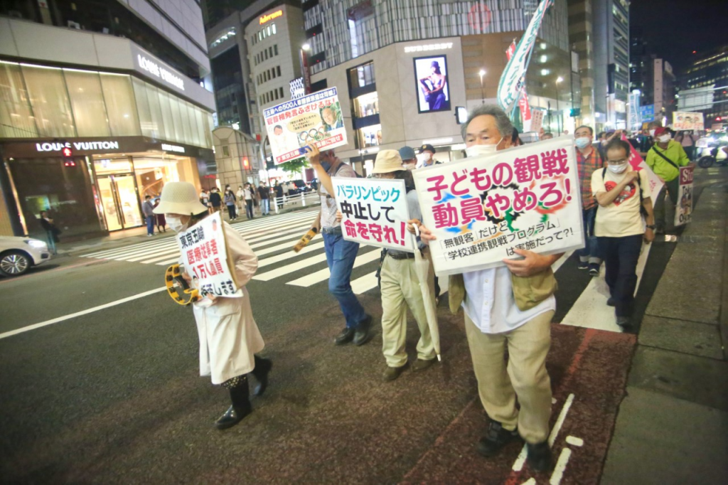 Demonstrators carry placards says stop the Paralympics and preserve people's Lives. (ANJ/ Pierre Boutier)