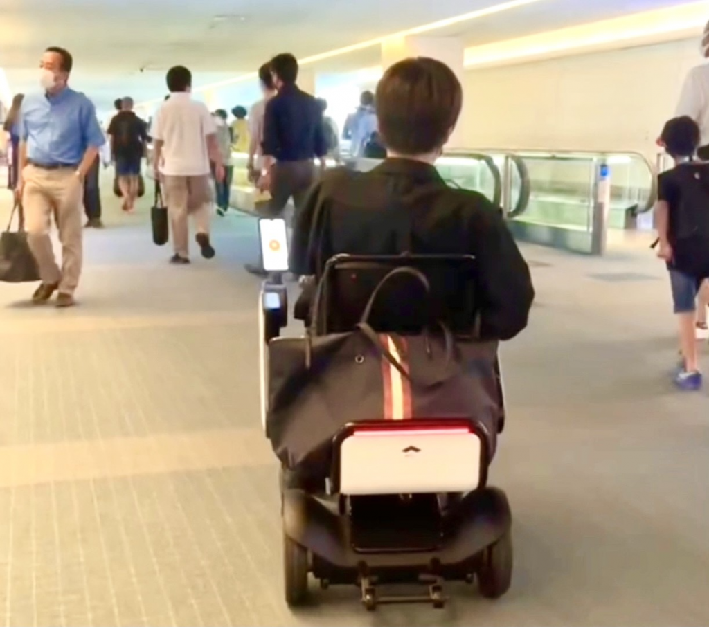 A passenger strolls in Tokyo Haneda airport on August 10, using the Whill Autonomous Mobile Chair (ANJ) 