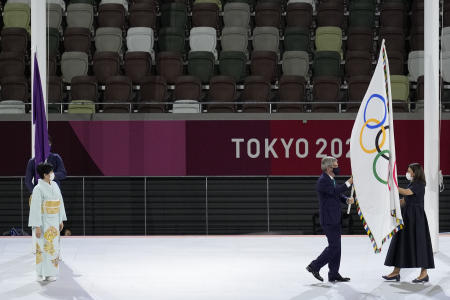 International Olympic Committee's President Thomas Bach hands over the Olympic flag to Paris mayor Anne Hidalgo, right, as Tokyo Gov. Yuriko Koike, left, looks on during the closing ceremony in the Olympic Stadium at the 2020 Summer Olympics, Sunday, Aug. 8, 2021, in Tokyo, Japan. (AP)