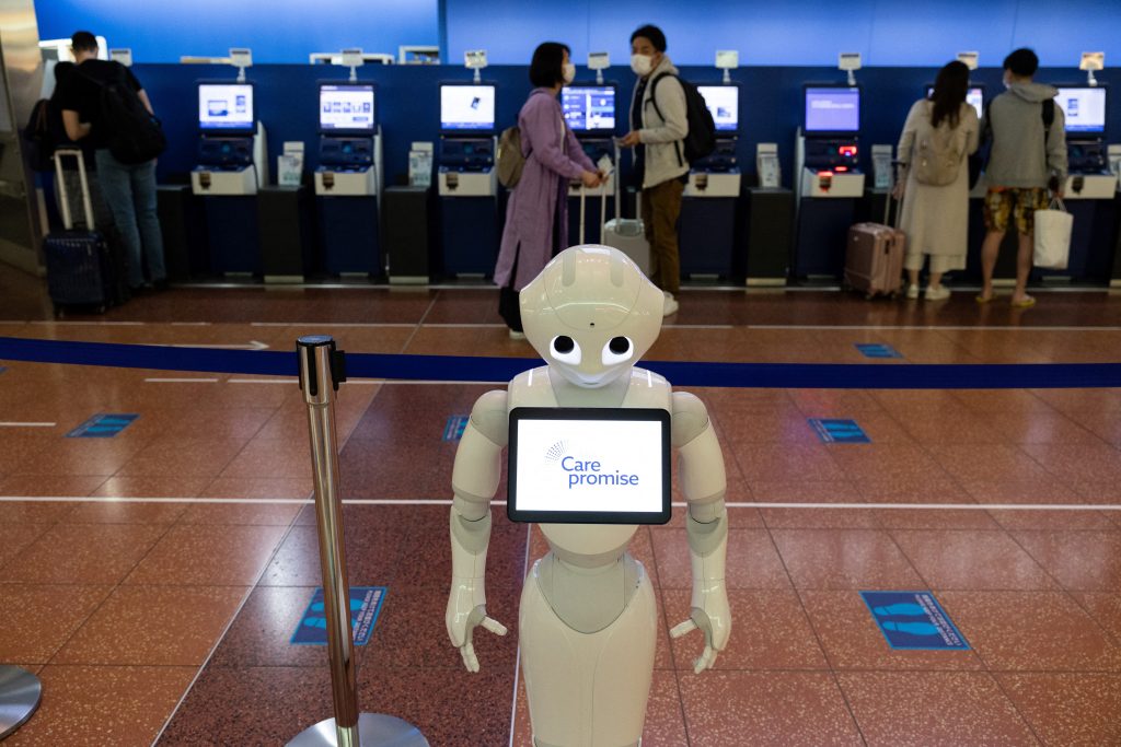 Japanese telecom giant Softbank's humanoid robot or greeting robot Pepper gives guidance to passengers at the domestic terminal of Haneda airport in Tokyo on April 30, 2021. (AFP)