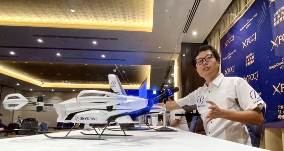 Tomohiro Fukuzawa, CEO of SkyDrive, holds a prototype of future drone sky taxi at a press conference in Tokyo (ANJ)
