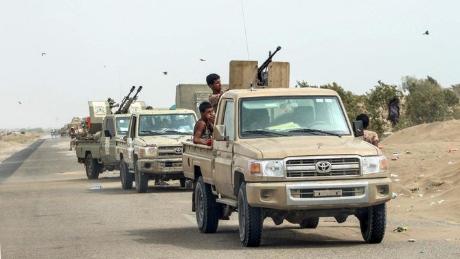 Yemeni fighters gather with armed pick-up trucks and armored vehicles on the side of a road during the offensive to seize the Red Sea port city of Hodeida from Iran-backed Houthis. (File/AFP)