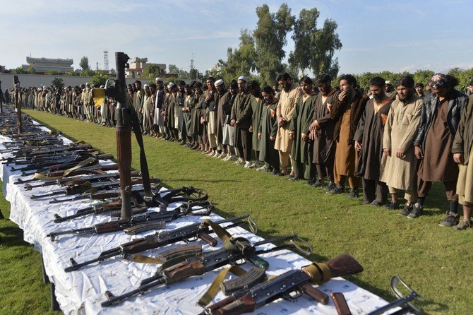 In this photograph taken on November 17, 2019 members of the Daesh group stand alongside their weapons, following they surrender to Afghanistan's government in Jalalabad. (File/AFP)