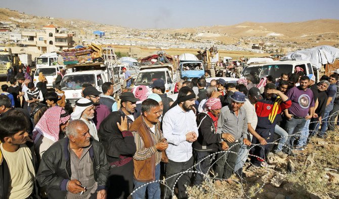 In this June 28, 2018 file photo, Syrian refugees gather in and near their vehicles getting ready to cross into Syria from the eastern Lebanese border town of Arsal, Lebanon. (AP)