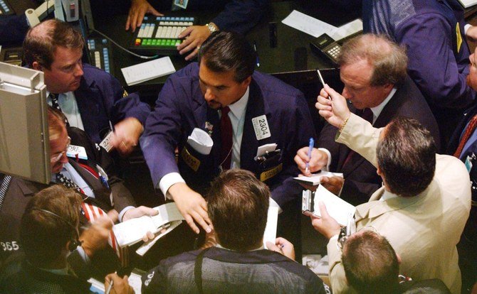 Traders on the floor of the New York Stock Exchange gather around a terminal on the day trading resumed after nearly a week off 17 September, 2001. (File/AFP)