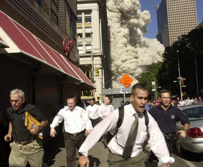 In one of Suzanne Plunkett’s iconic photos depicting the events of 9/11, a man wearing a shirt and tie runs into the frame, his face a picture of terror. (AP)