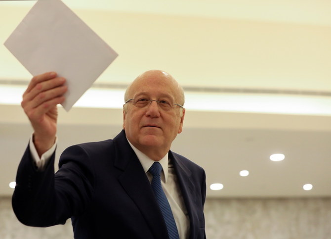 Lebanon's Prime Minister Najib Mikati holds the cabinet line up after meeting with Lebanon's President Michel Aoun at the presidential palace in Baabda. (Reuters)