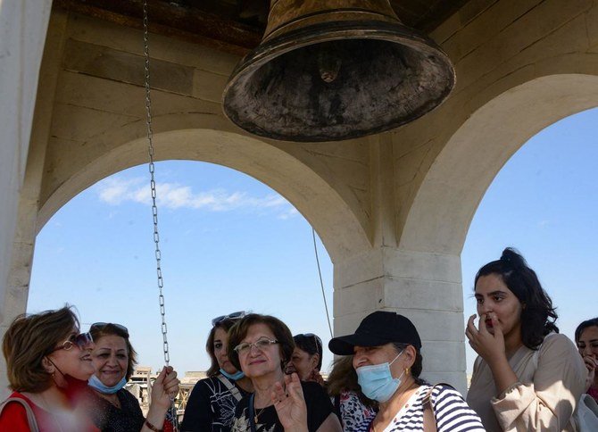 People ring the newly inaugurated bell at Syriac Christian church of Mar Tuma in Iraq's second city of Mosul. (AFP)